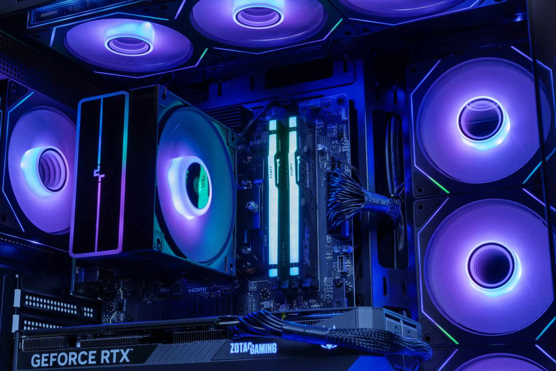 gaming-pc-test-innenansicht Nahaufnahme im PC-Innenraum mit Turmkühler, zwei beleuchteten DDR5-Speichermodulen, ummantelten Stromkabeln und Grafikkarte